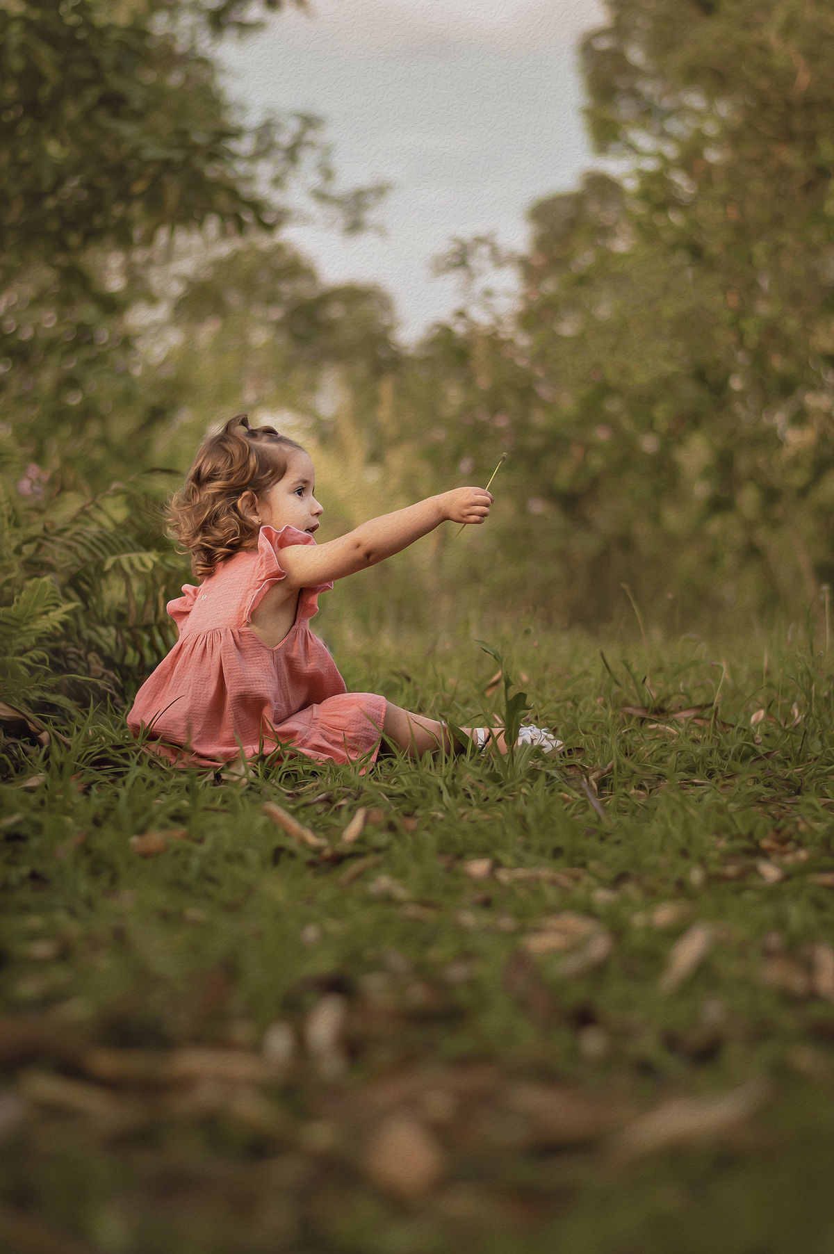 foto menina estendendo o braço segurando matinho