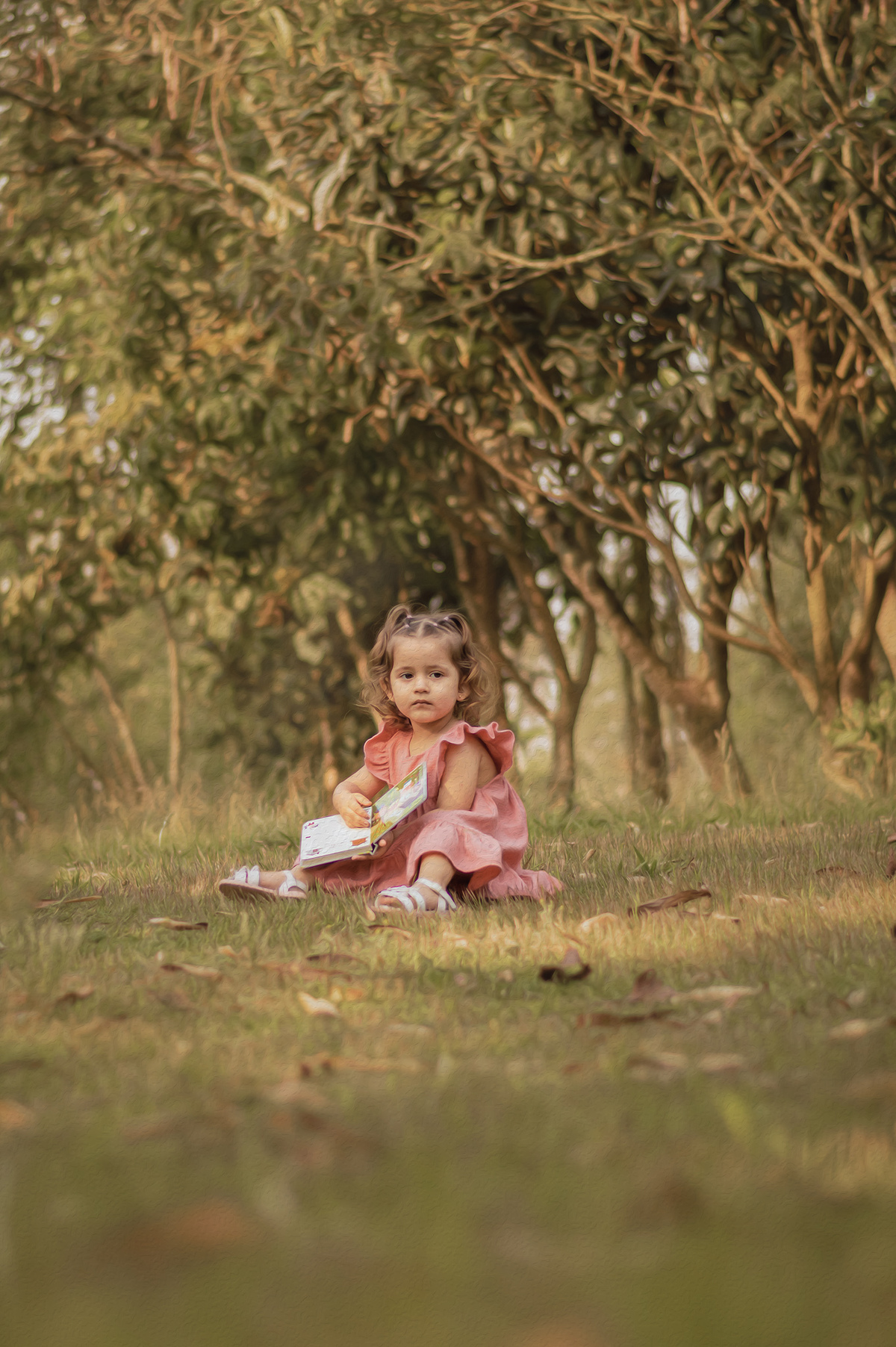 foto menina na natureza segurando livro olhando para a câmera