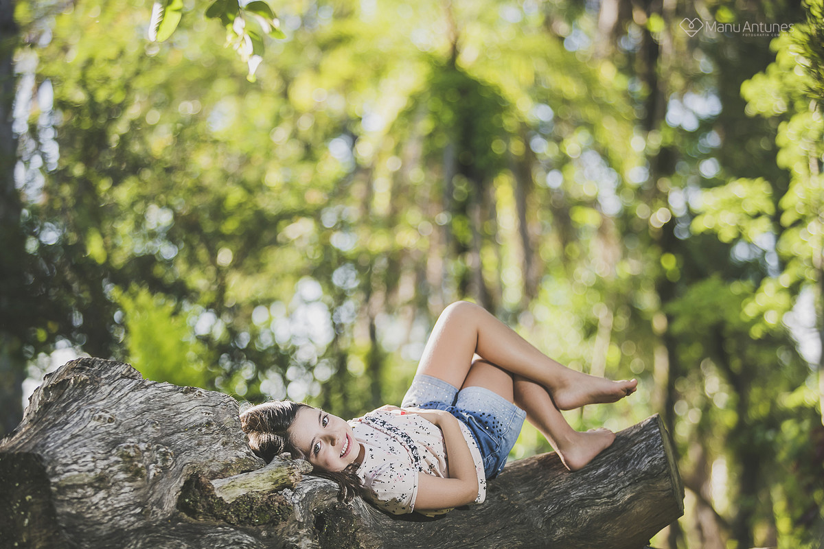 menina sentada no tronco da árvore