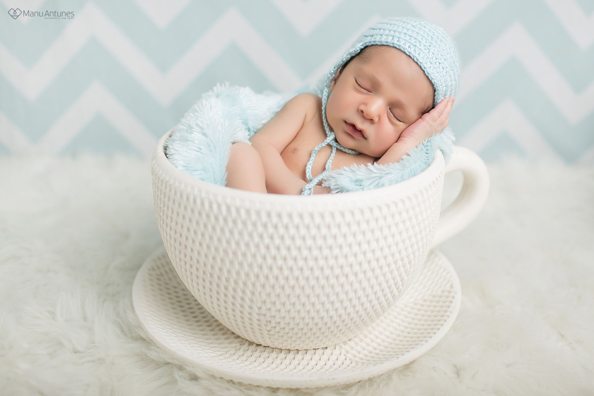 recém nascina da xícara fazendo pose