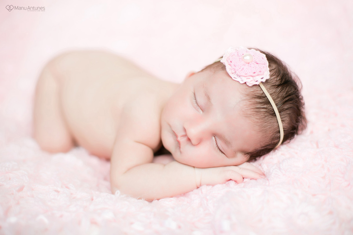 recém-nascido com laço rosa