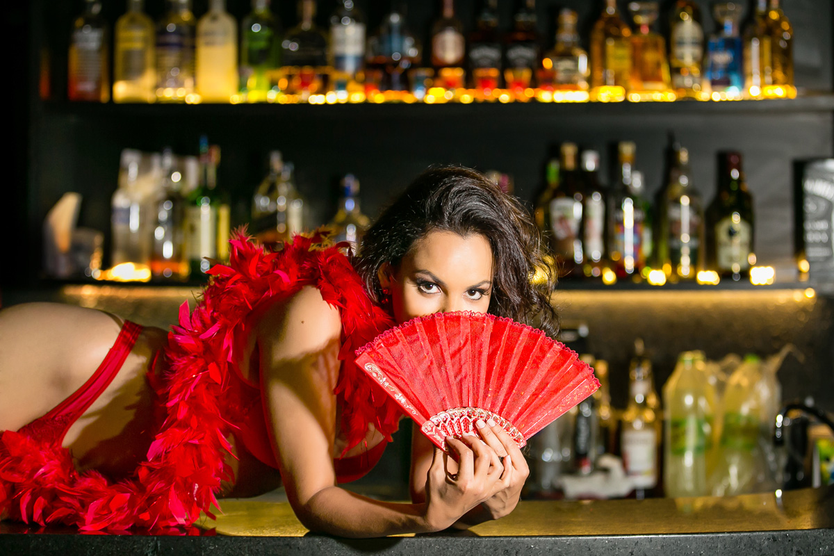 mulher de lingerie vermelha com leque no balcão