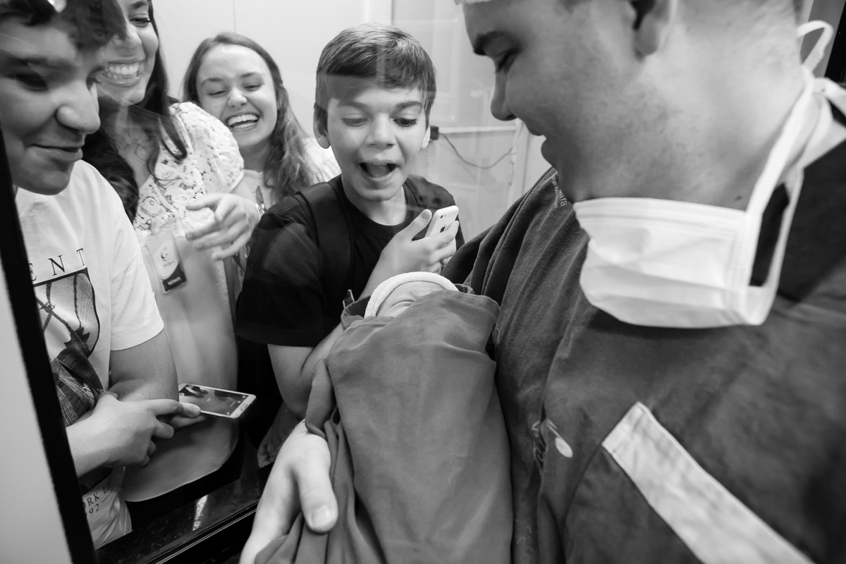 pai mostrando o bebê pelo vidro