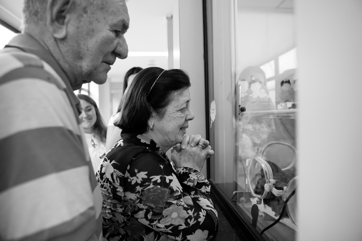 avós olhando a neta na incubadora