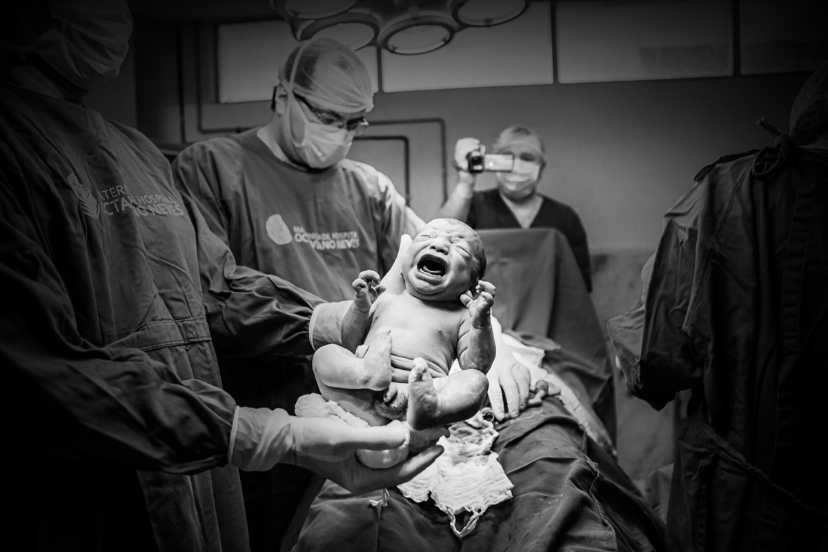 médico mostrando o bebê para a câmera
