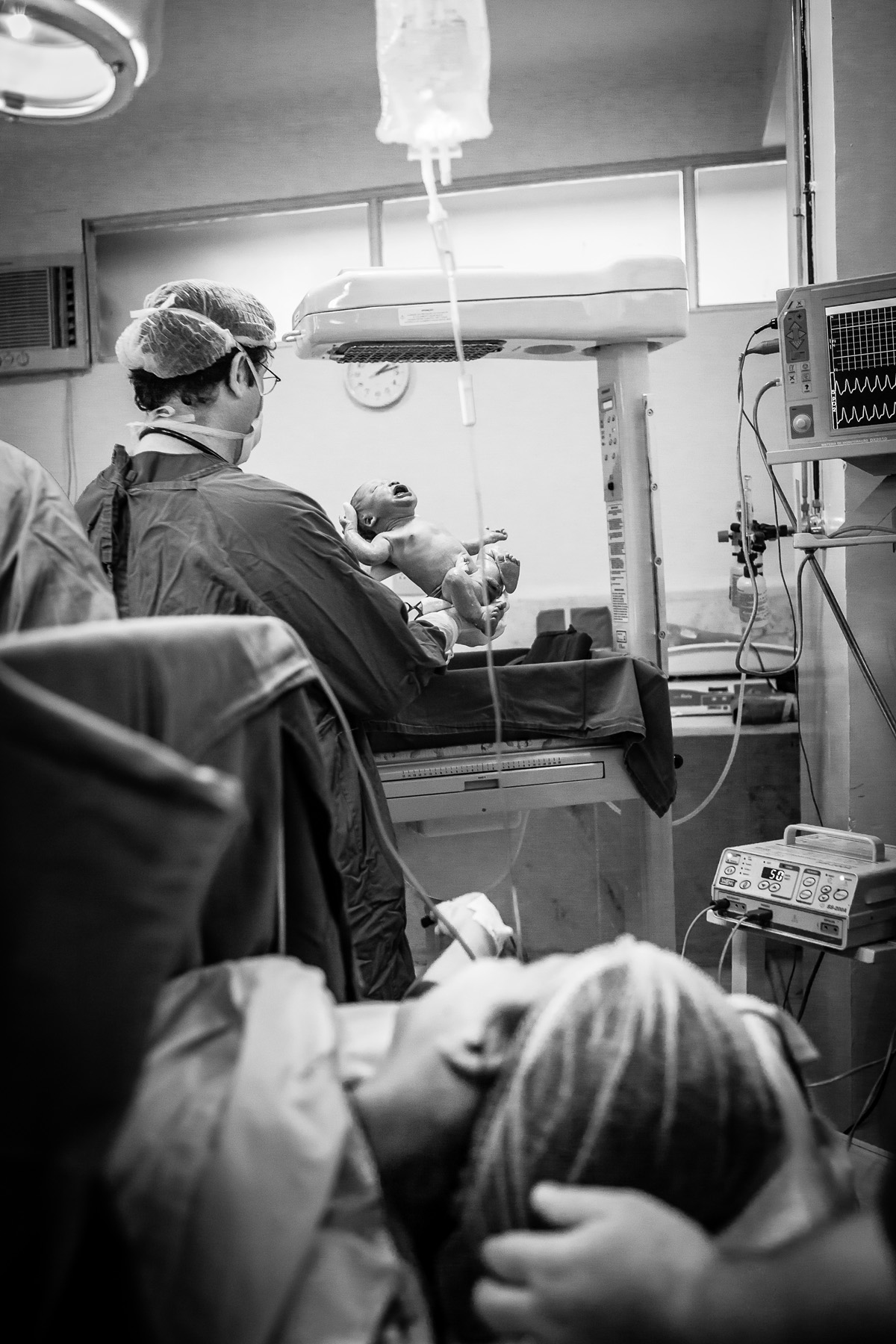 mãe observando os médicos com bebê