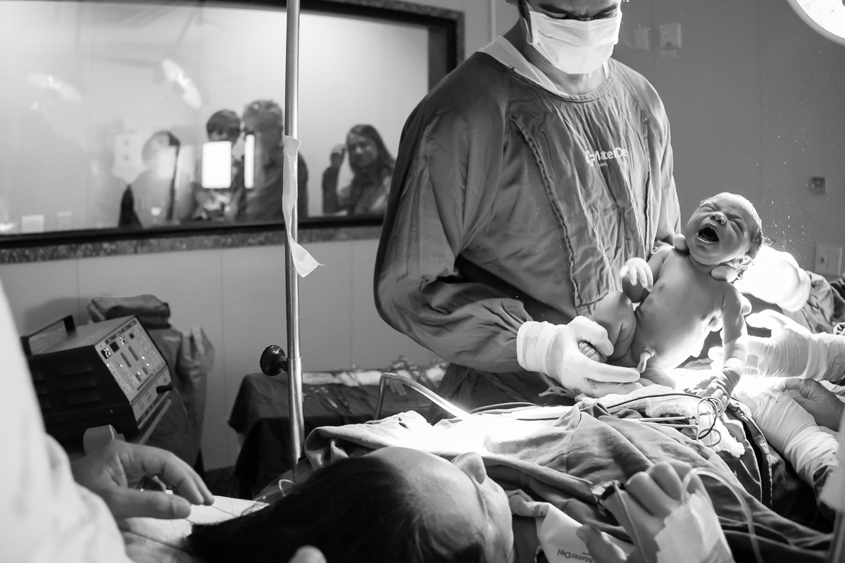 médico mostrando o bebê para a mãe