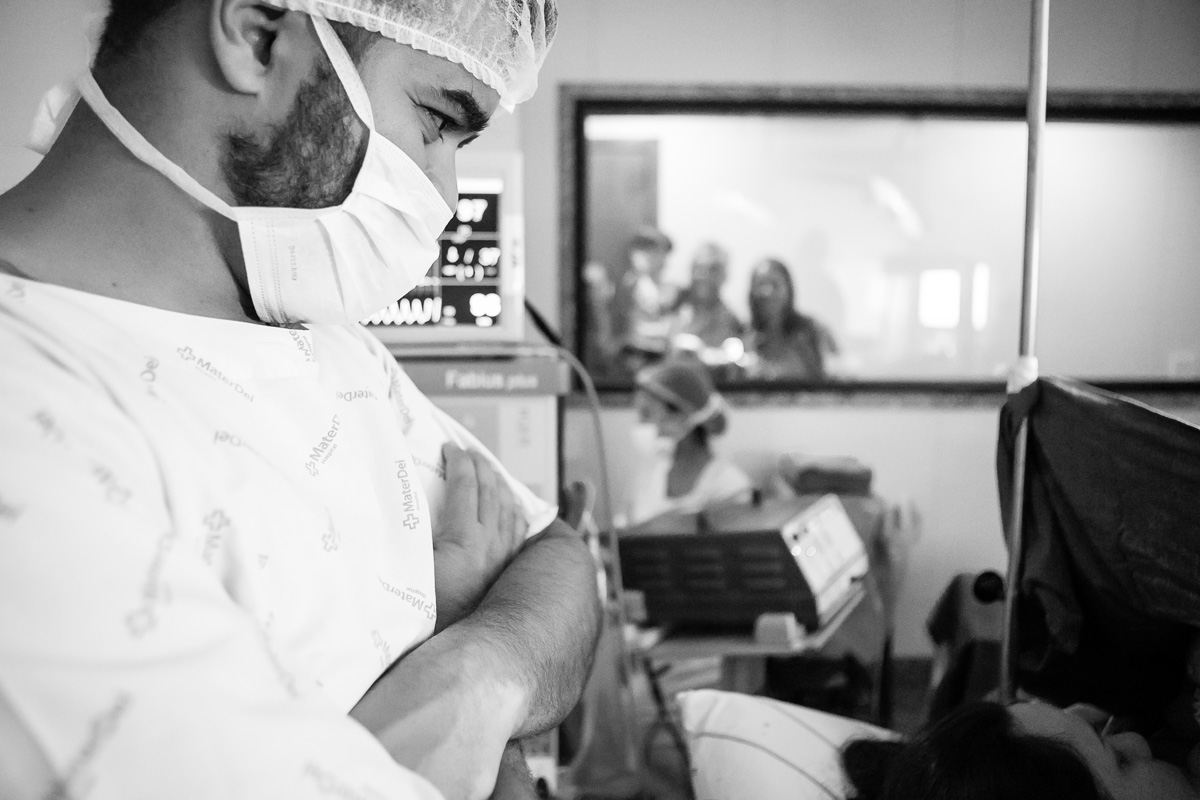 pai olhando o bebê com a mãe