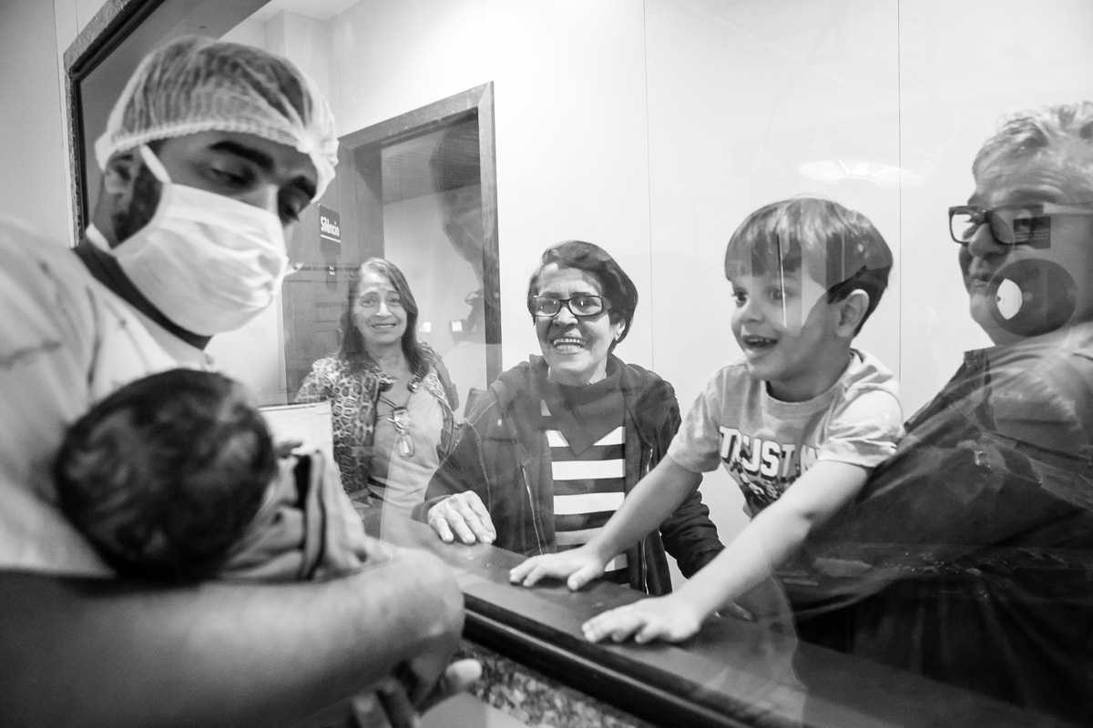 menino olhando o pai com o bebê