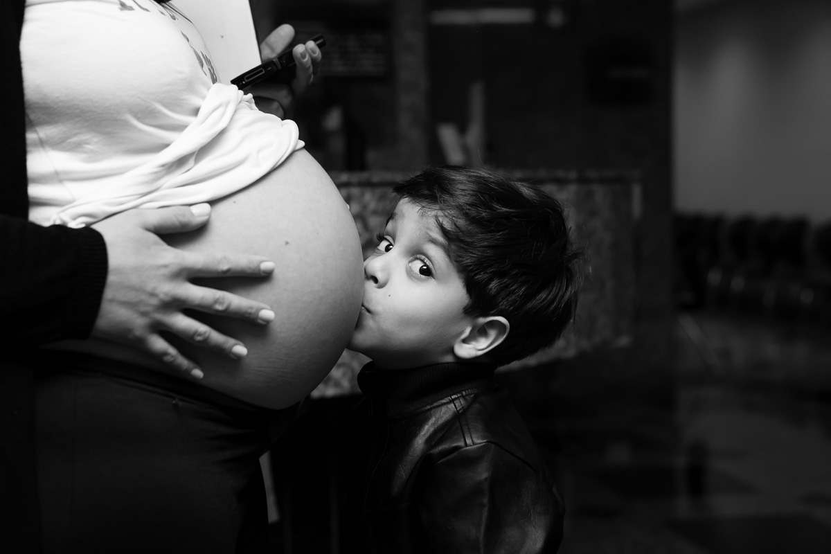 filho beijando a barriga da mãe
