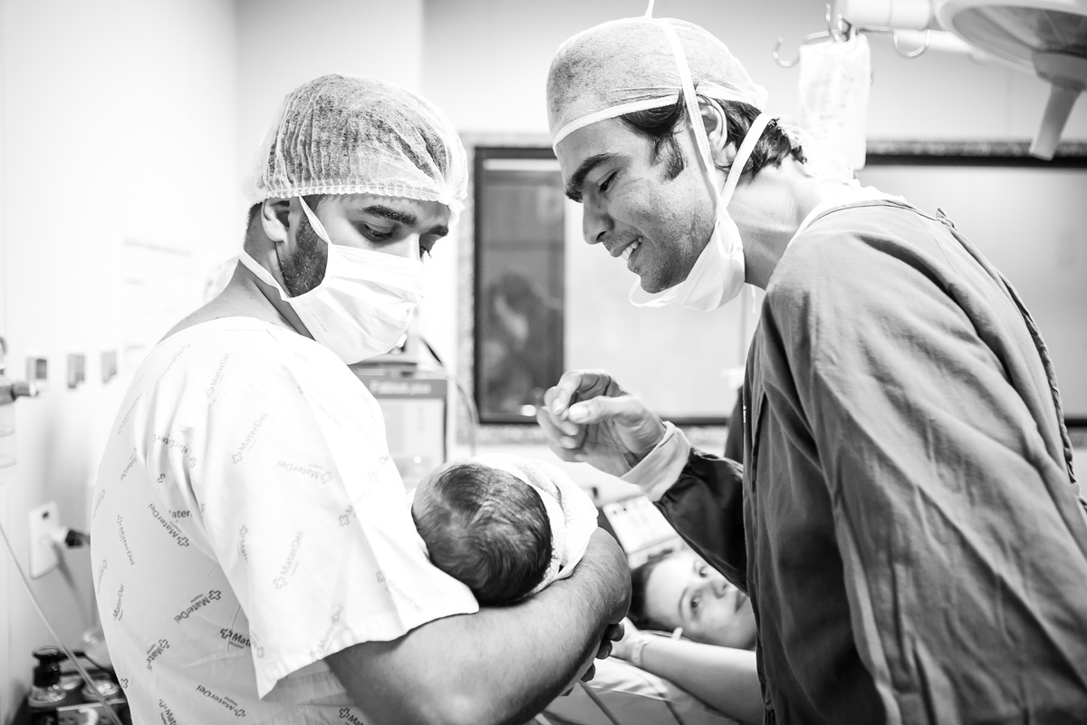 médico examinando bebê no colo do pai