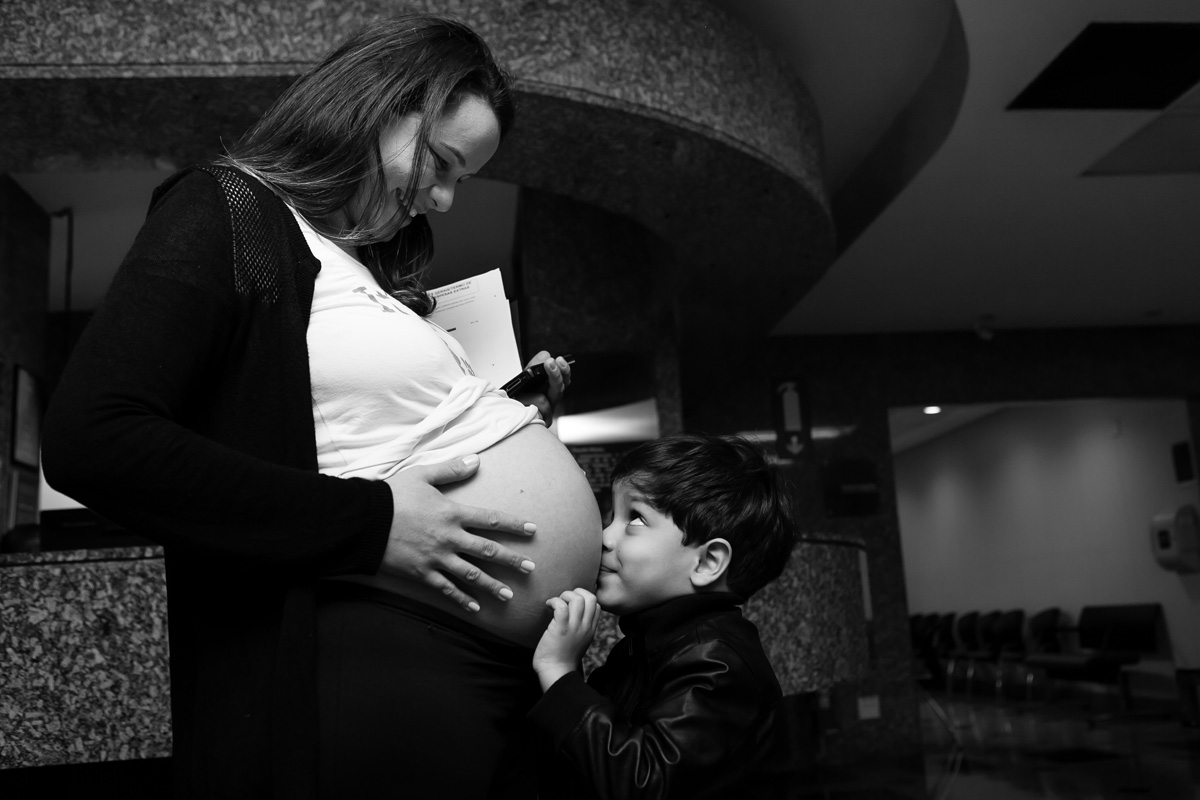 filho beijando a barriga e a mãe olhando para ele