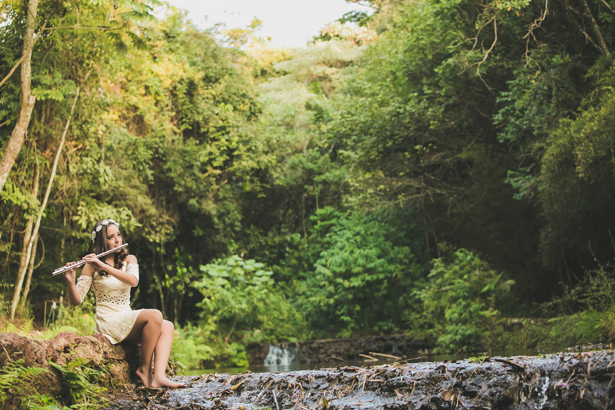 menina tocando flauta com o pé na água