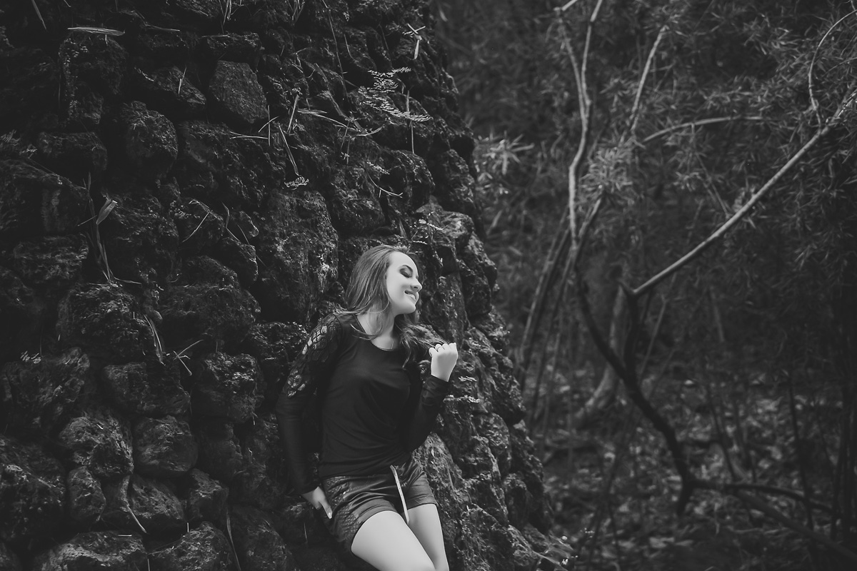 menina encostada no muro de pedra