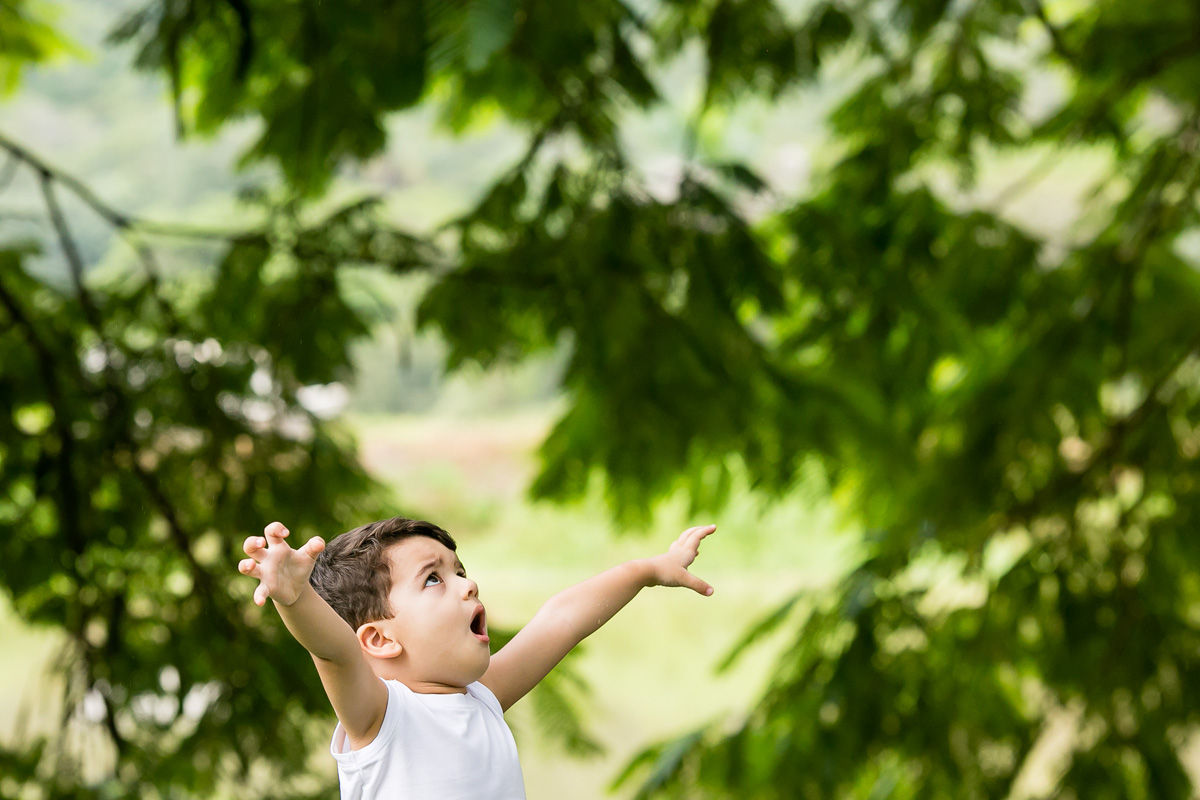 menino brincando com as mãos para cima