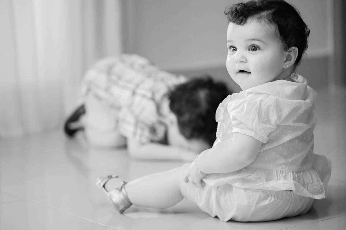 menina sentada no chão e o irmãozinho deitado