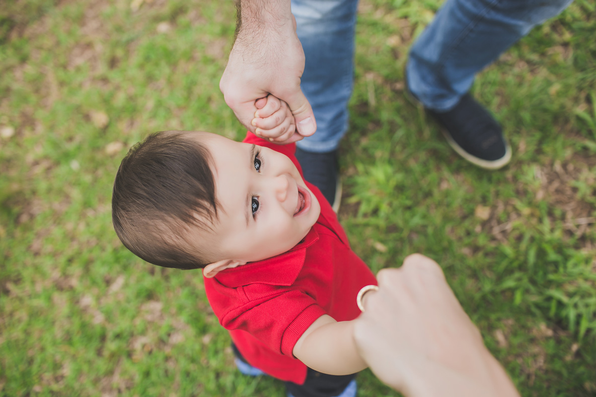 pais segurando a mão do filho