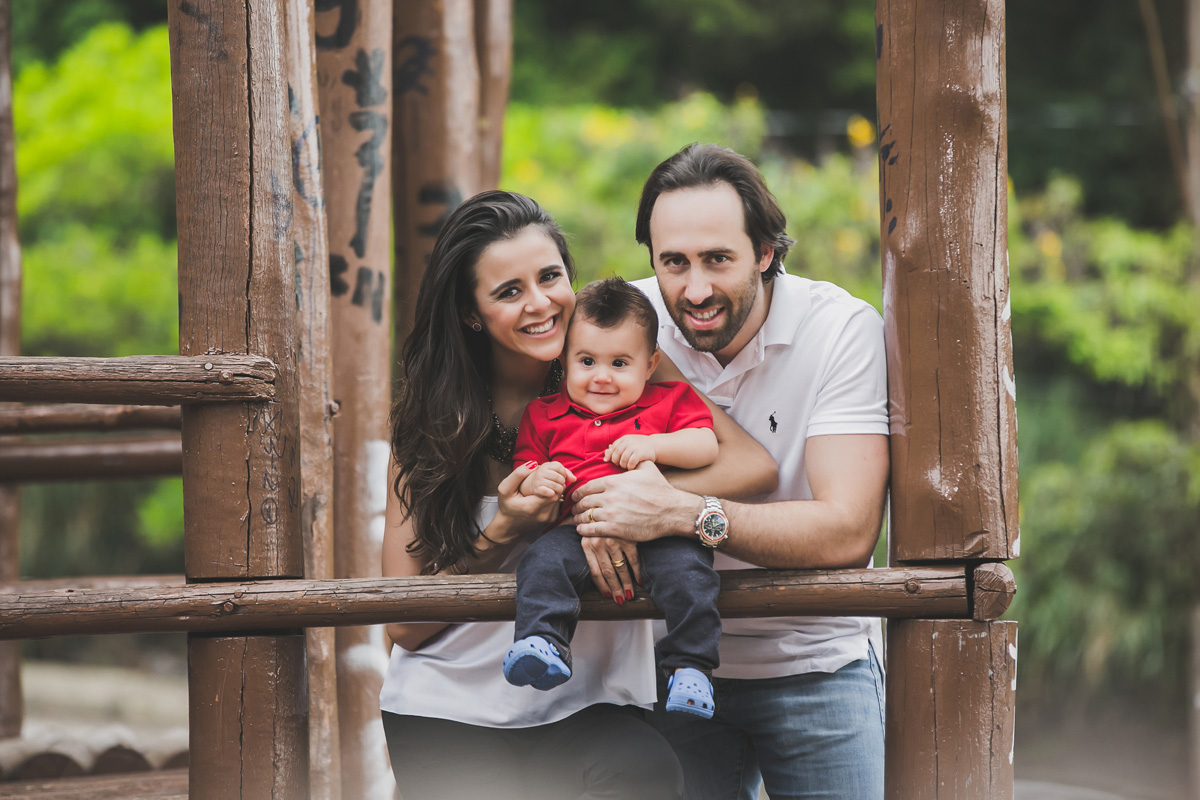 pais segurando o filho na casa da árvore