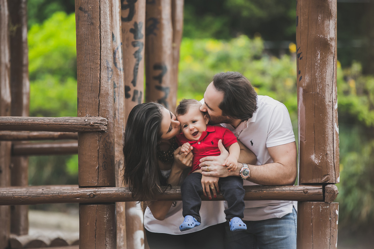 pais beijando o filho na árvore