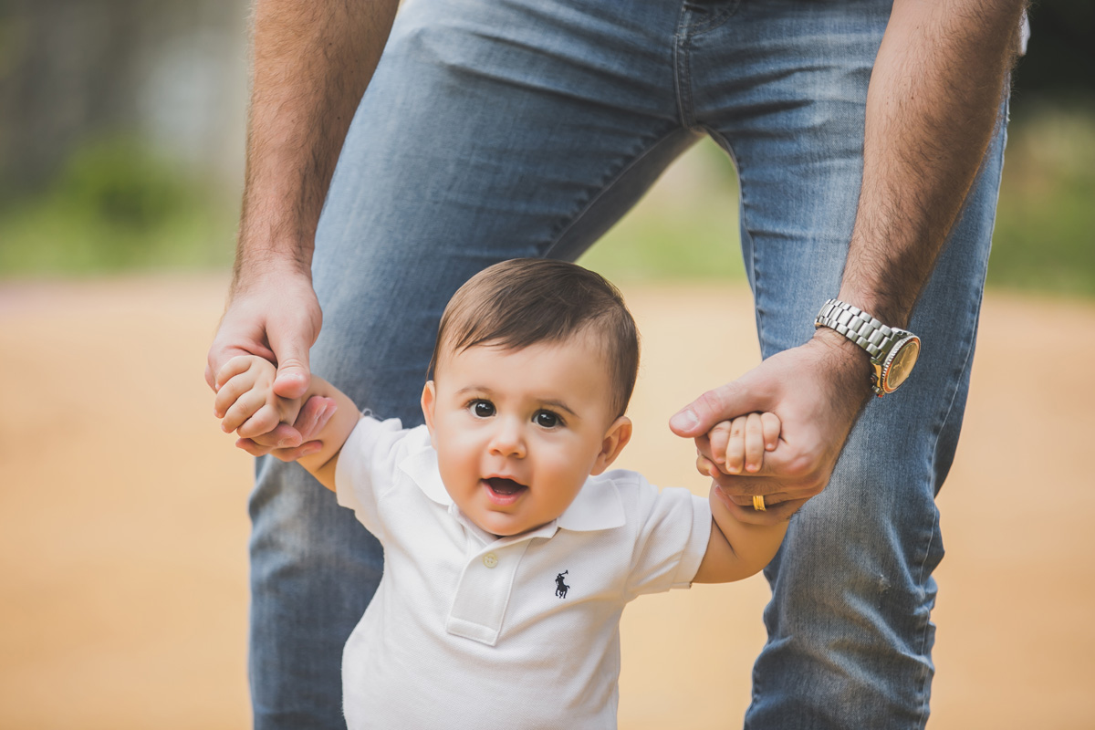 menino segurando a mão do pai