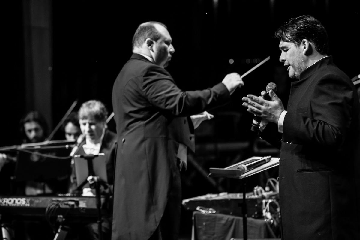 homem cantando junto com o maestro