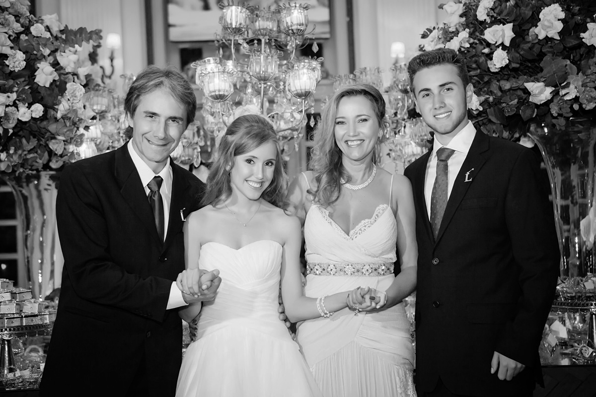 menina sorrindo com os pais e irmão