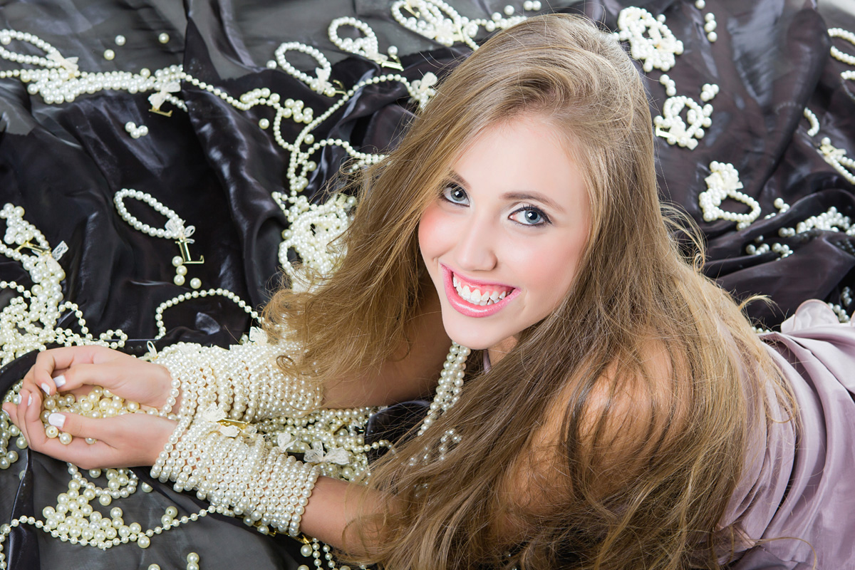 garota com pérolas e sorrindo