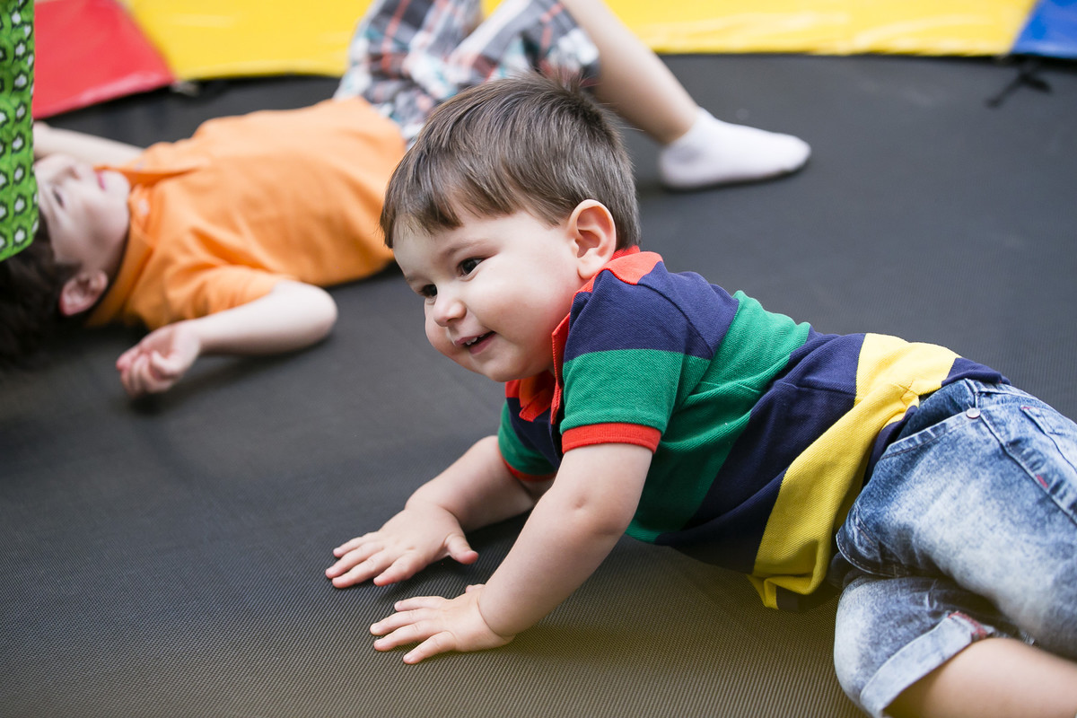 menino deitado da cama elástica