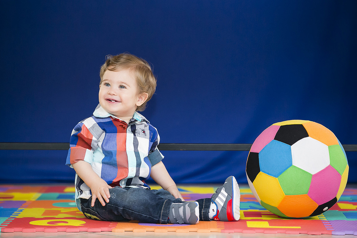 criança sentada com bola
