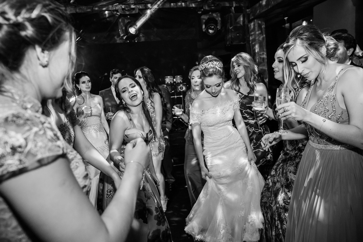 noiva segurando o vestido na festa