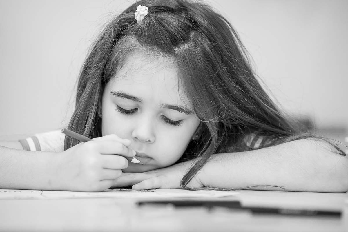 criança apoiada na mesa