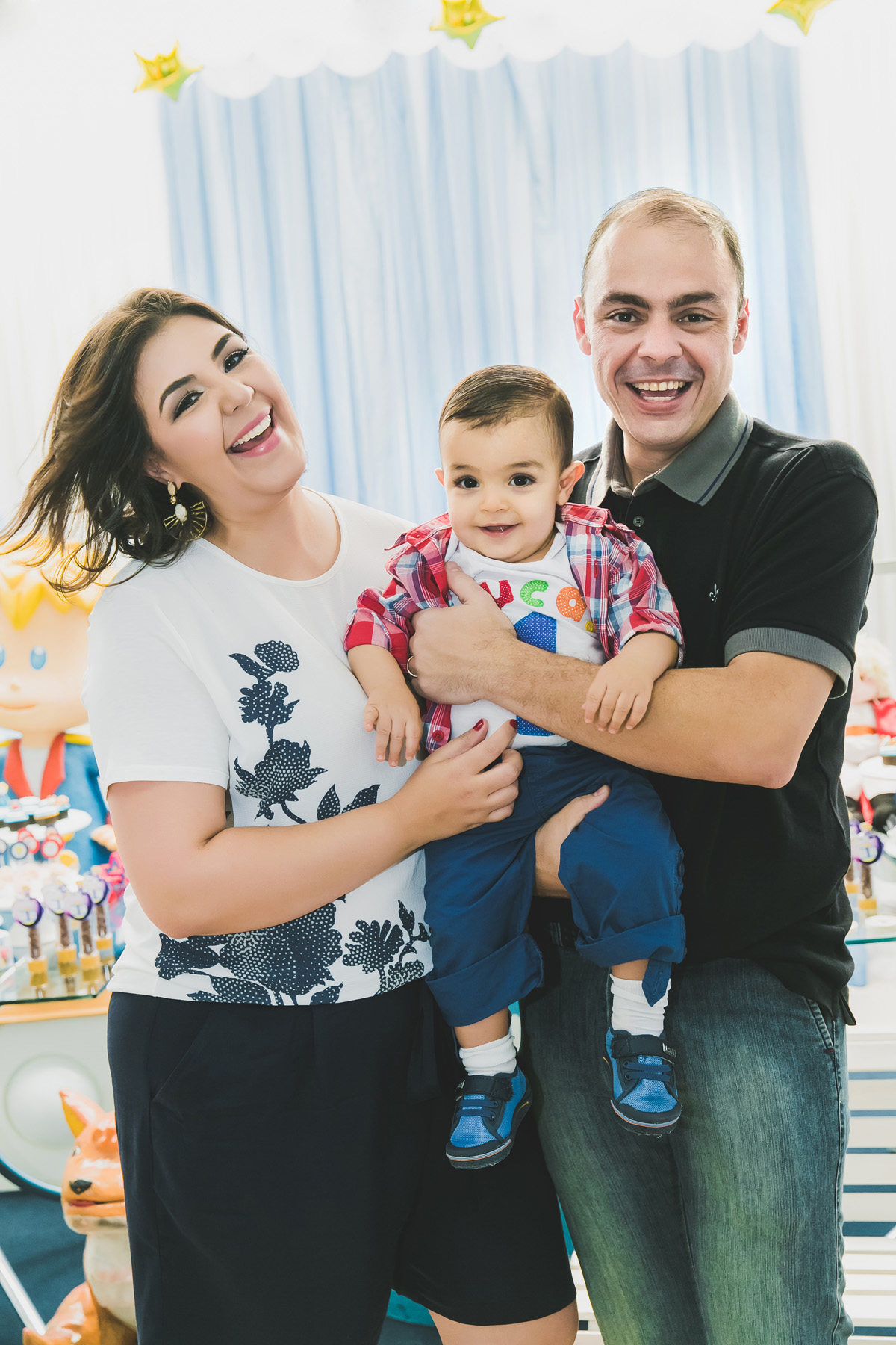 o aniversariante nos braços dos seus pais