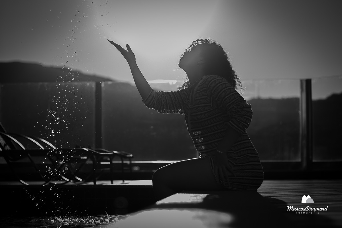Modelo na beira da piscina jogando água