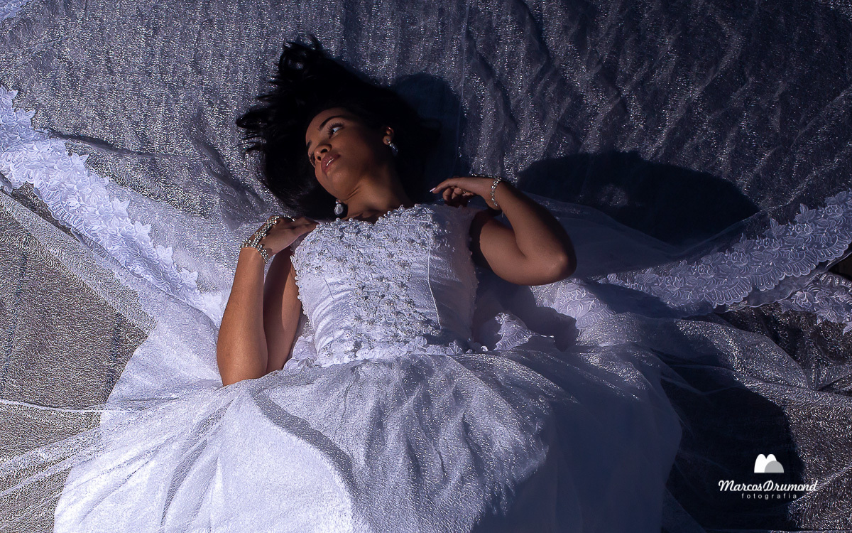 Noiva deitada com as mãos no ombro