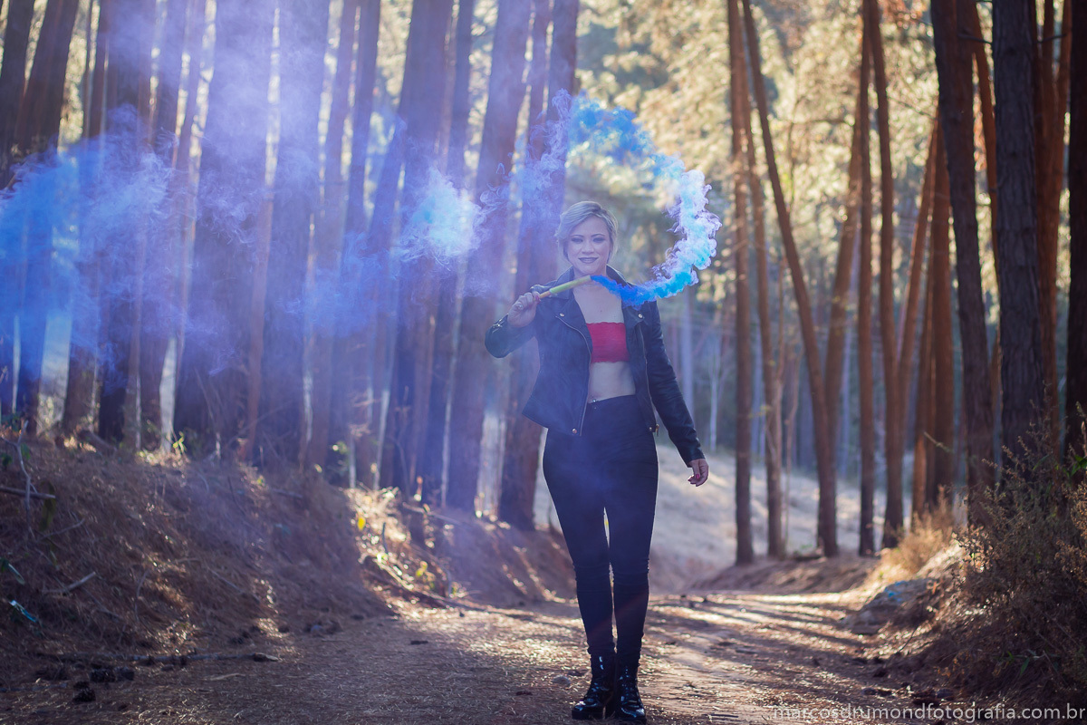Foto feita com uma modelo usando uma bomba de fumaça azul