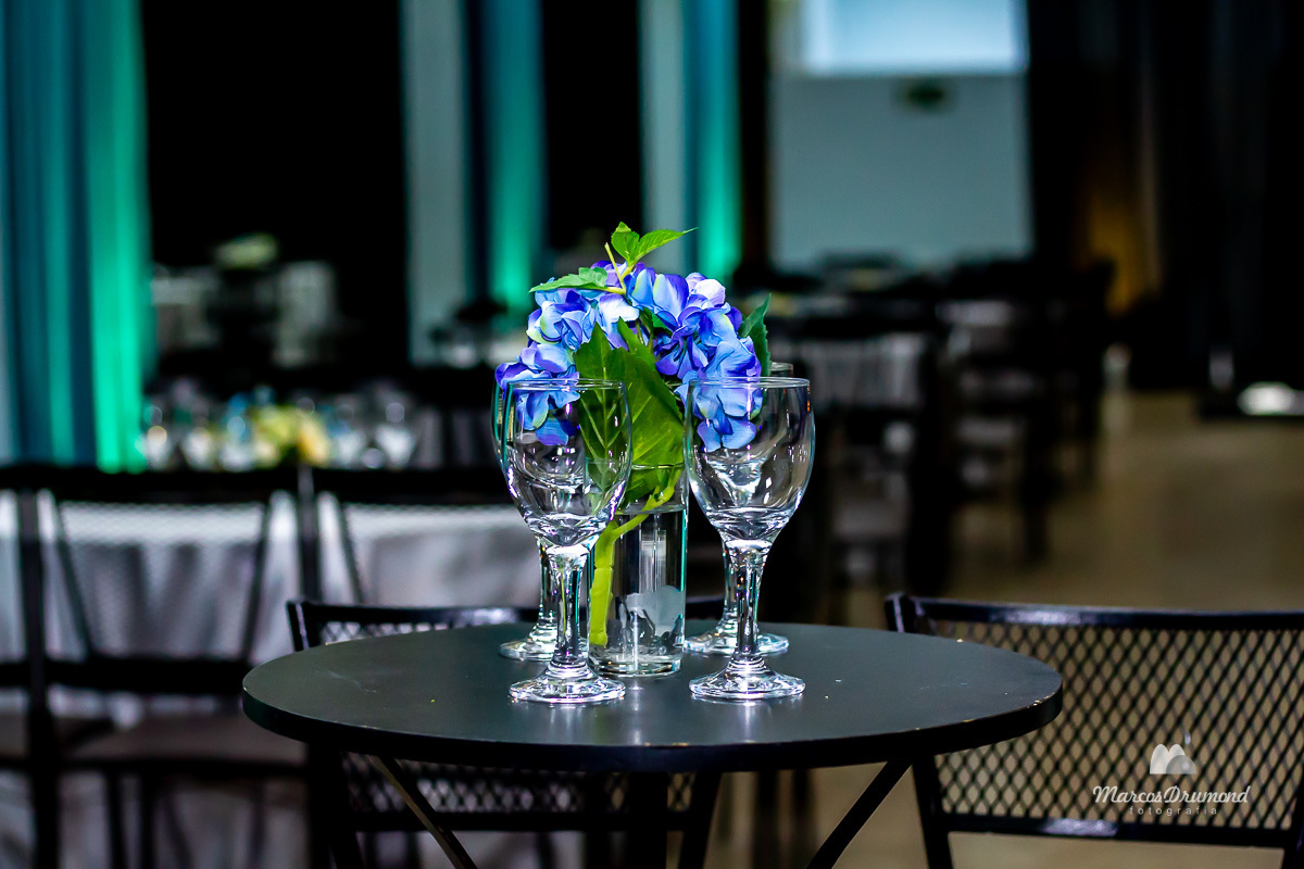 Decoração da mesa no aniversário da debutante Natielle na cidade de Itabira/MG, com belos copos encima da mesa e flores de decoração nos mesmos