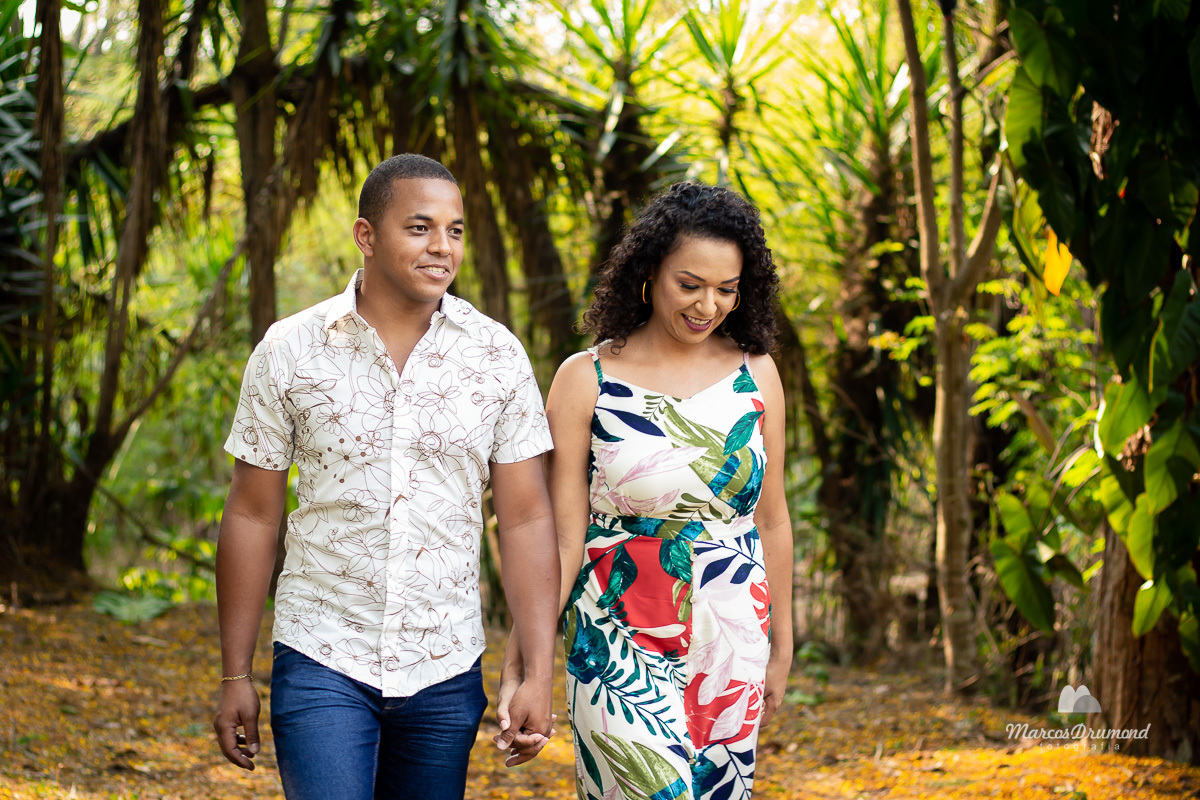 Fotografia de pré casamento onde o casal está caminhando de frente sorrindo