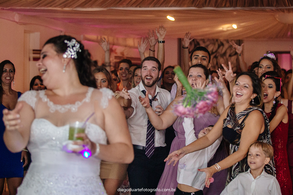 noiva jogando o bouquet, convidados , noiva rindo, bouquet para casamento, vestido de noiva, madrinhas, solteiras, encalhadas, 