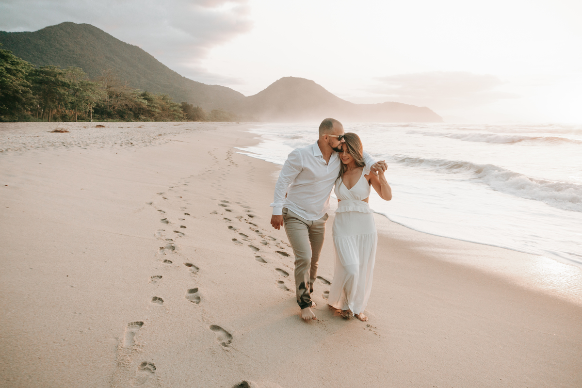 Casal abraçado durante ensaio ao pôr do sol em Ubatuba.