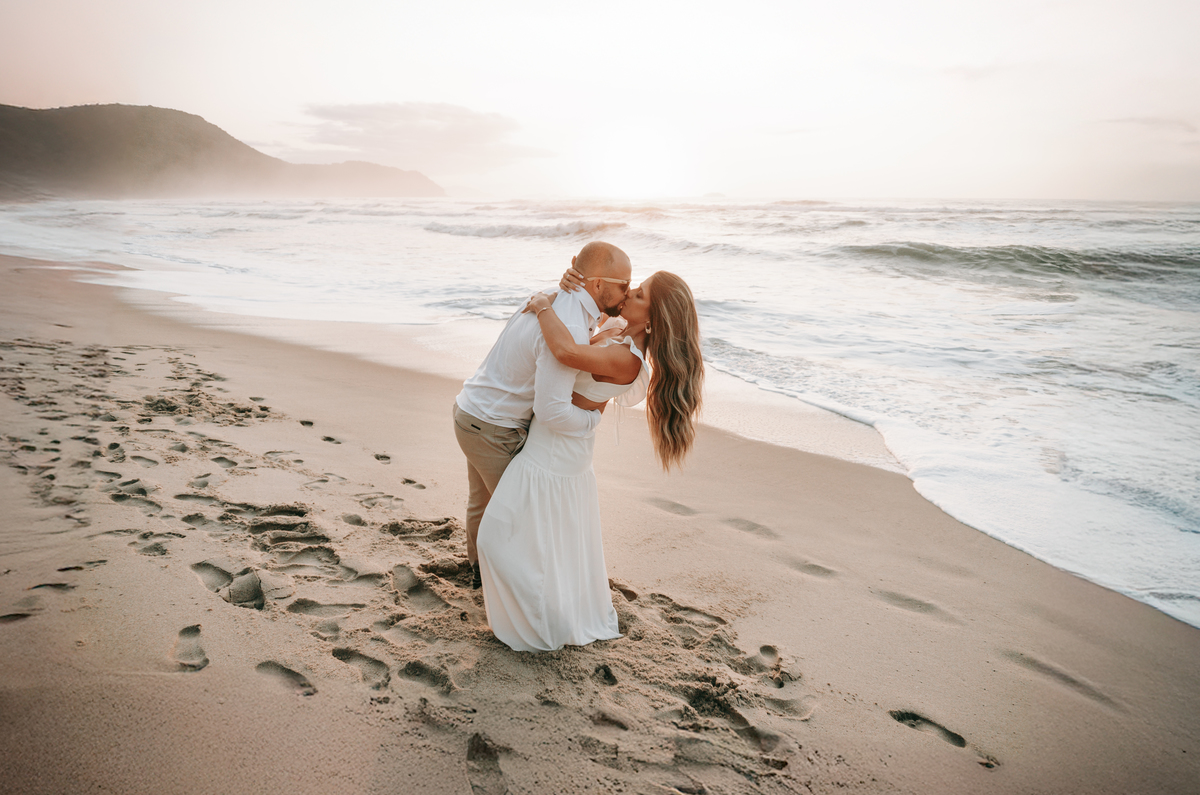 Casal fotografado na Praia de Itamambuca em Ubatuba durante ensaio pré-casamento ao pôr do sol com luz natural.