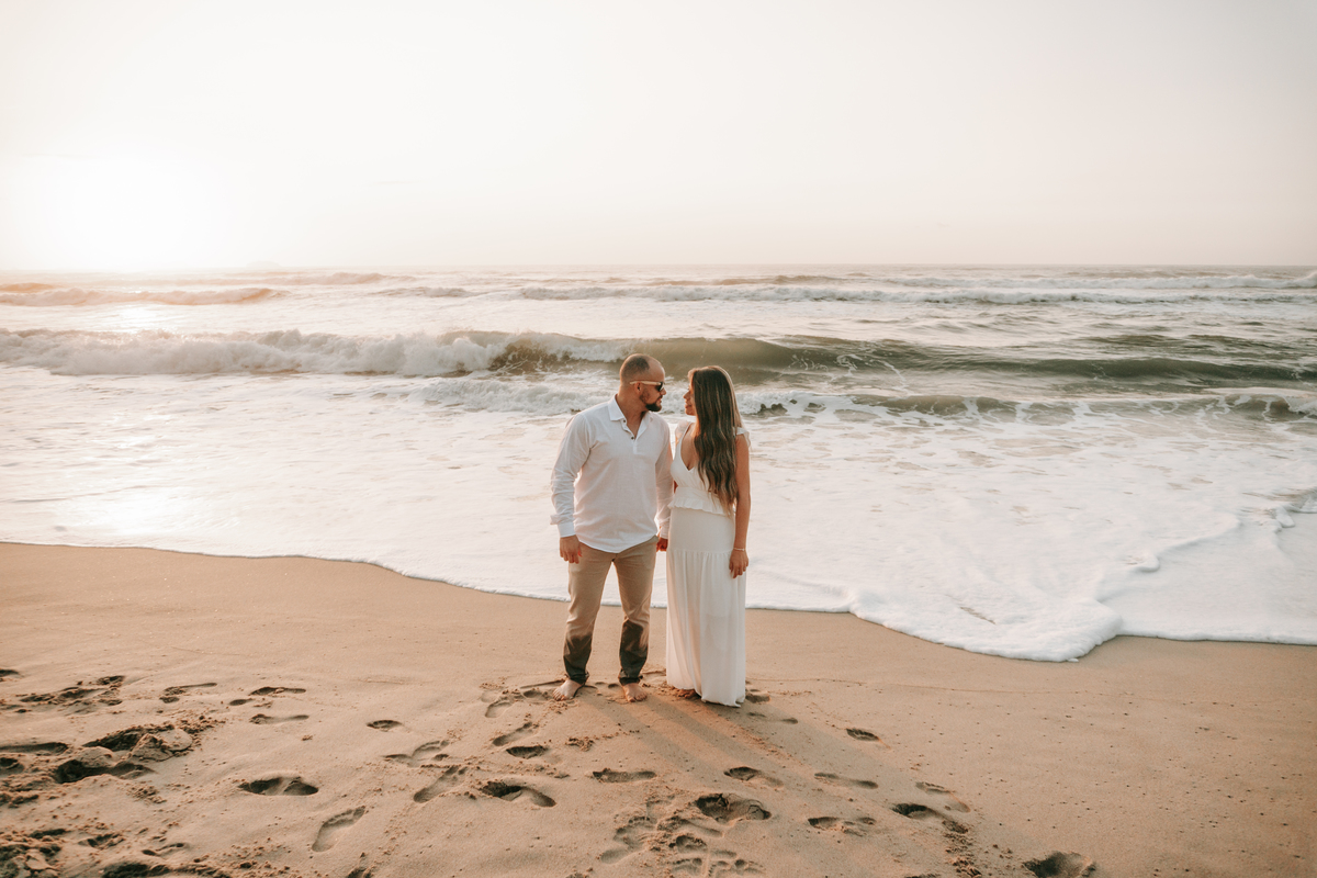Casal fotografado na Praia de Itamambuca em Ubatuba durante ensaio pré-casamento ao pôr do sol com luz natural.