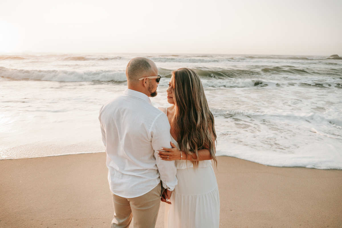 Casal fotografado na Praia de Itamambuca em Ubatuba durante ensaio pré-casamento ao pôr do sol com luz natural.