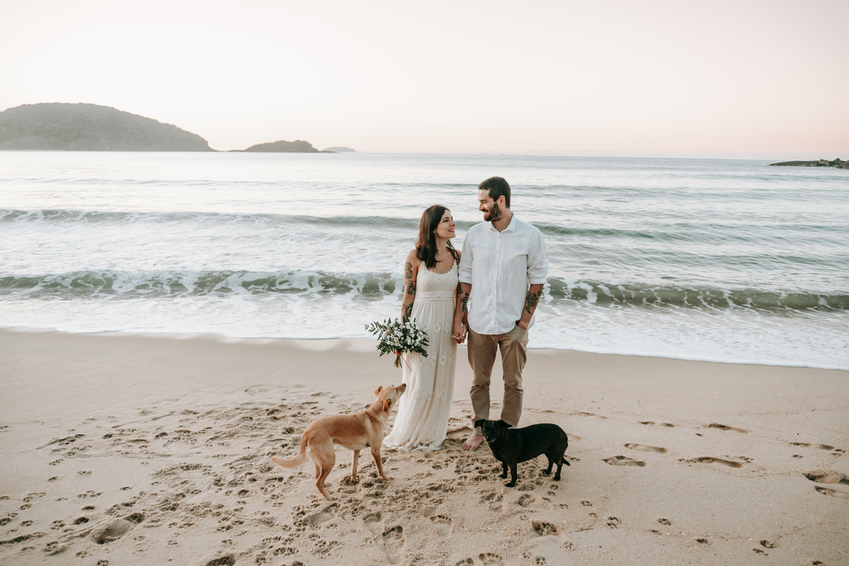 Casal brincando com seu cachorro durante ensaio pré-wedding ao ar livre
