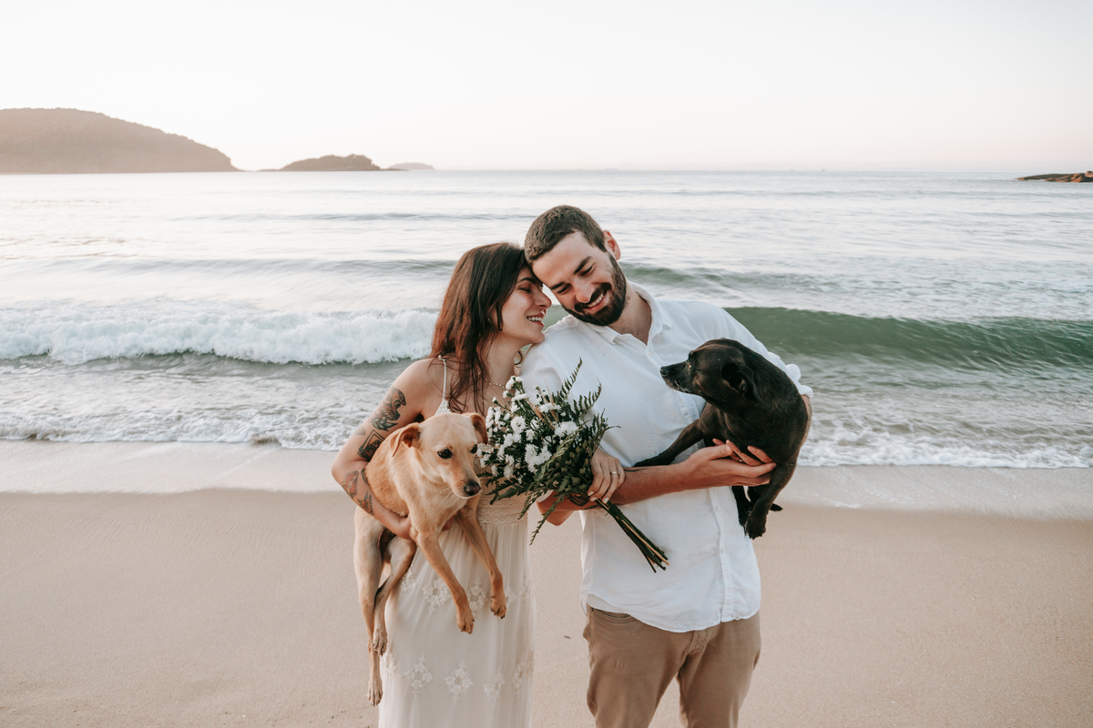 Casal brincando com seu cachorro durante ensaio pré-wedding ao ar livre