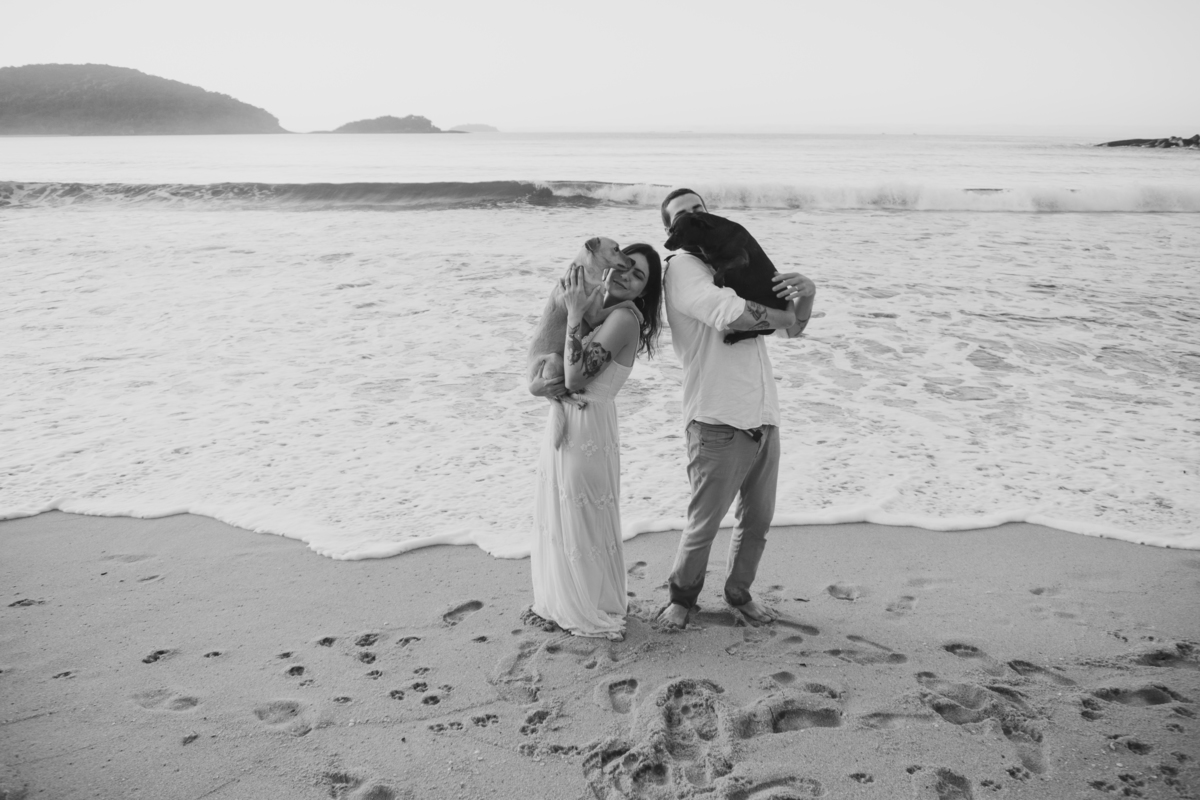 Casal brincando com seu cachorro durante ensaio pré-wedding ao ar livre