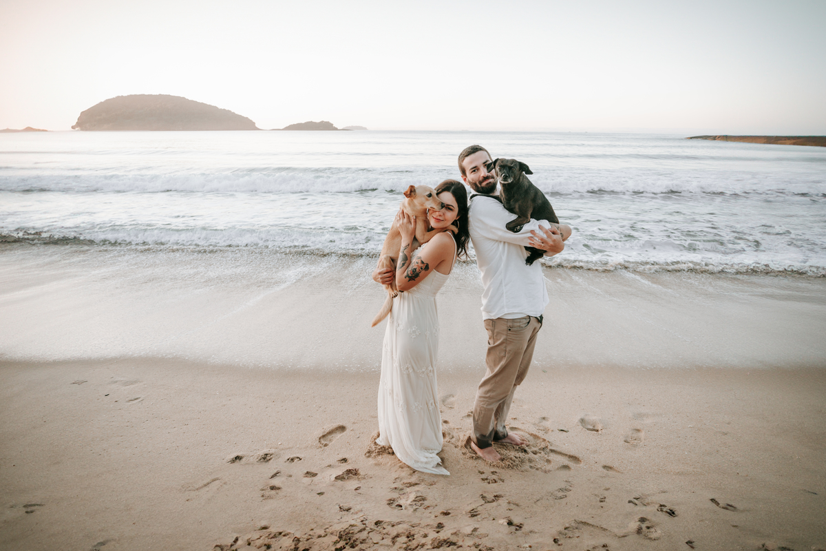 Casal brincando com seu cachorro durante ensaio pré-wedding ao ar livre