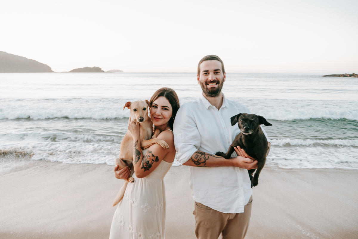 Casal brincando com seu cachorro durante ensaio pré-wedding ao ar livre