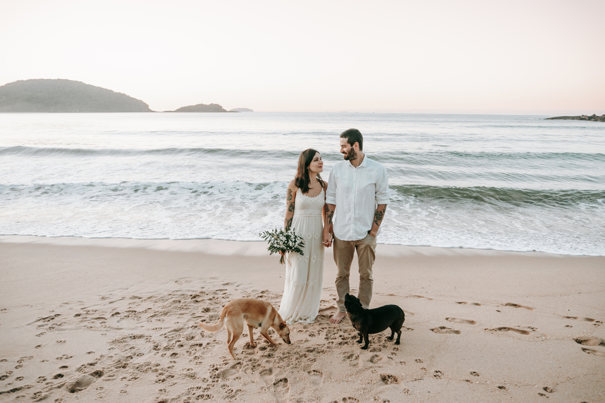 Casal brincando com seu cachorro durante ensaio casal ao ar livre