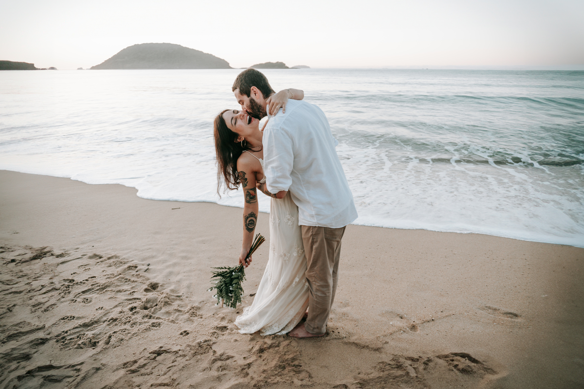 Casal fotografada na Praia do Prumirim em Ubatuba durante ensaio pré-wedding ao pôr do sol com luz natural.