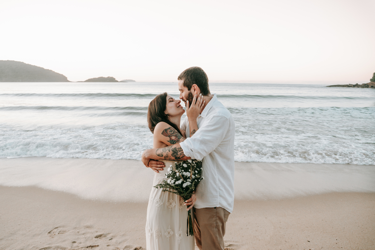 Casal fotografada na Praia de Itamambuca em Ubatuba durante ensaio pré-wedding ao pôr do sol com luz natural.